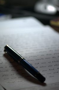Artistic photo of a pen on a hand-written letter.