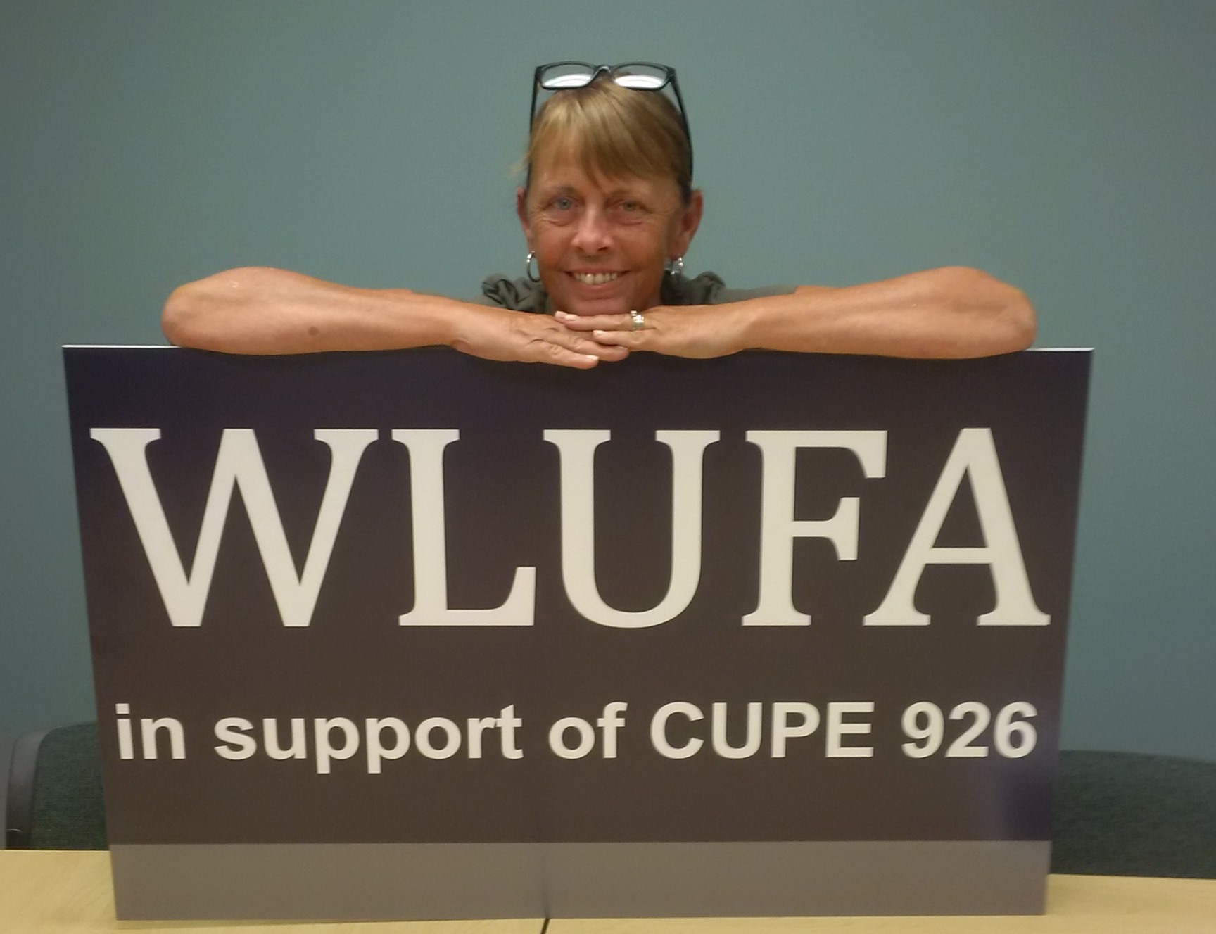 Michele Kramer as WLUFA president over sign that reads "WLUFA in support of CUPE 926".